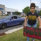 Cherizar Crippen posts a sign to voice her opposition to musical artist R. Kelly’s performance at the Greensboro Coliseum.